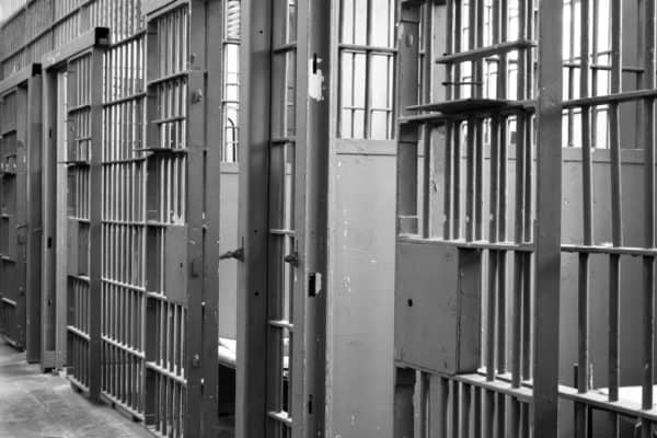 Pregnancy and Birth in California Jails and Prisons 1 This image portrays a prison hallway with cell doors open.