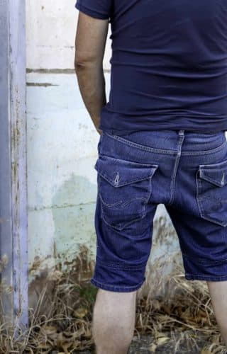 Public Urination Laws and Sex Offender Registration in California 1 a man urinating in public against a white wall