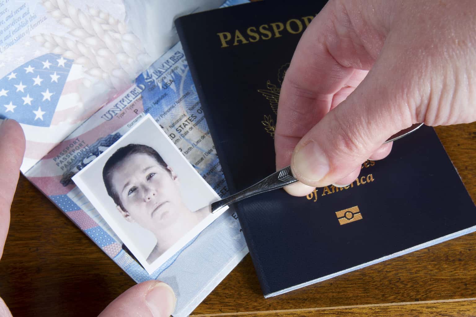 A Vista Identity Theft Attorney Can Help You Fight the Charges 1 A man's hands using tweezers to place an image over a photo on a passport.
