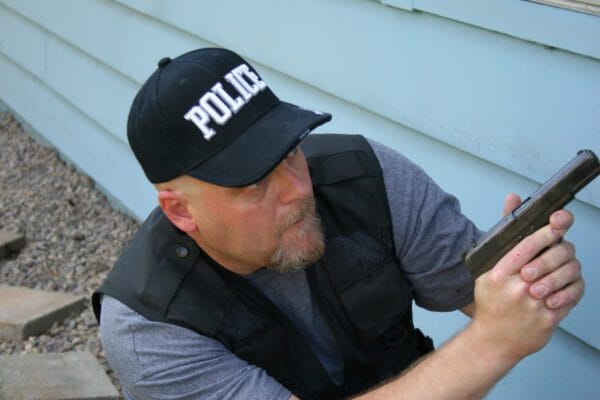 Police Are Turning to AI Systems to Write Up Reports 1 An officer squats with gun drawn. New AI technology could allow him to write a police report based on statements he makes into his bodycam.