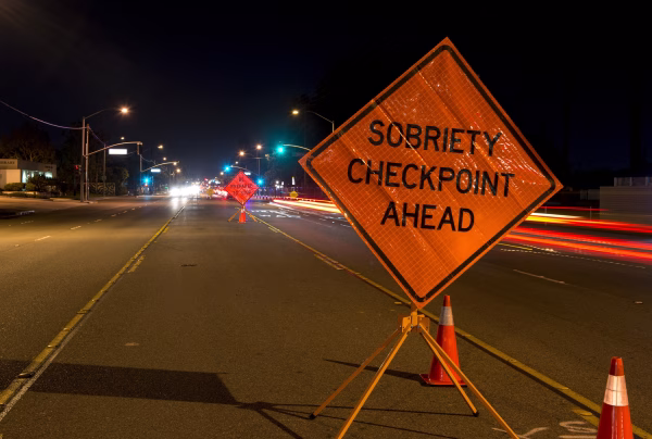 A sign reading "sobriety checkpoint ahead" illustrates article on San Diego DUI checkpoint laws